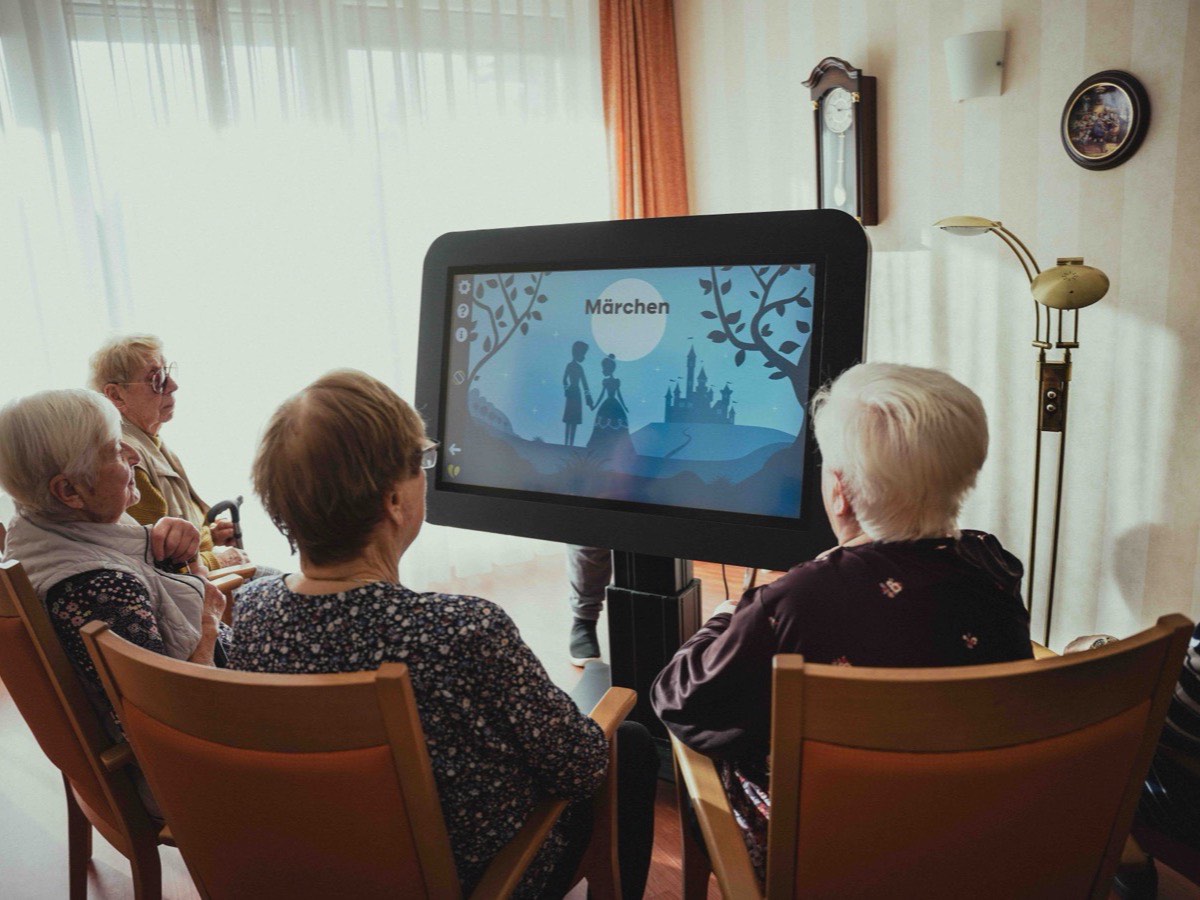 Bewohnerinnen im Sitzkreis vor dem großen CareTable